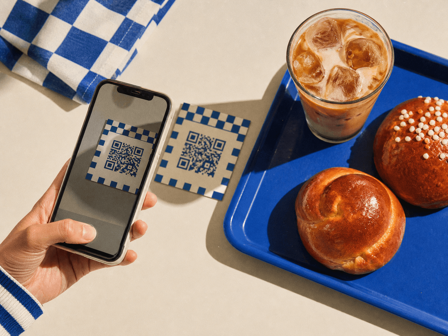 Tangan memindai QR meja di samping roti dan kopi